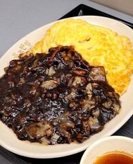 Classic jajangmyeon with thick noodles in a rich black bean sauce, garnished with sliced cucumber...