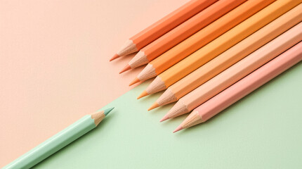 Fototapeta premium A group of vibrant colored pencils including orange peach pink and mint green are artfully arranged on a pastel background suggesting creativity and art supplies