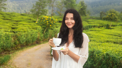 Smiling Woman Holding Tea Cup in Lush Green Plantation, Sri Lanka