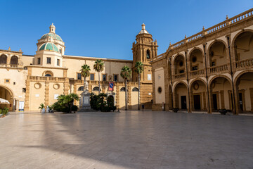 Historic church and arched buildings in a sunny Mediterranean square