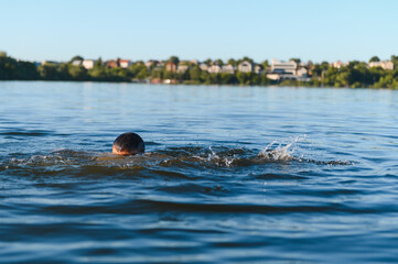 Man drowning in a lake near the city, desperate struggle for survival