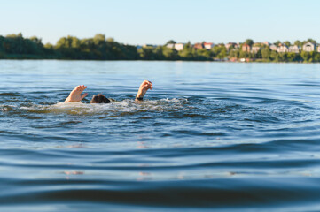 Man drowning in a river is raising hands asking for help