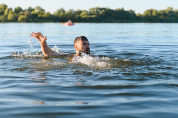 Man drowning in lake during summer vacation, seeking help