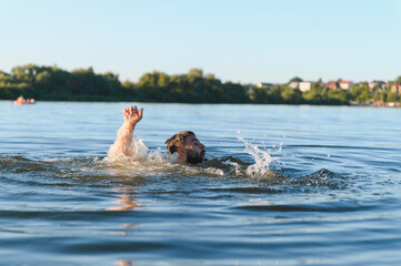 Man drowning in river raising hand asking for help