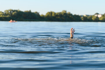 Man drowning in a river is raising hand for help