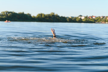 Drowning man reaching for help in deep blue water