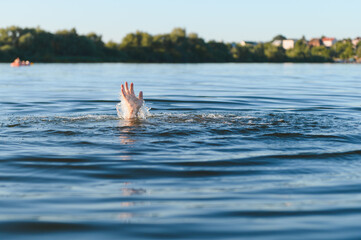 Hand of drowning man reaching for help in water
