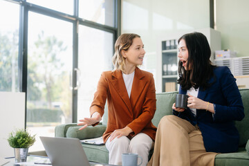 Two businesswomen collaborate using a tablet in a stylish office setting. Perfect for concepts
