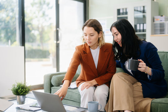 Two businesswomen strategizing with a tablet in a professional office. Highlight teamwork, leadership,