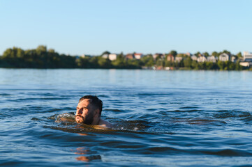 Bearded man drowning in river during summer day
