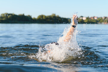 Man drowning in a lake raising hand asking for help
