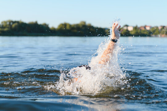 Man drowning in a lake raising hand asking for help