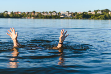 Fototapeta premium Man drowning in water raising hands asking for help