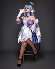 Girl in blue cosplay clothes and wig posing in studio on dark background. © Alexander