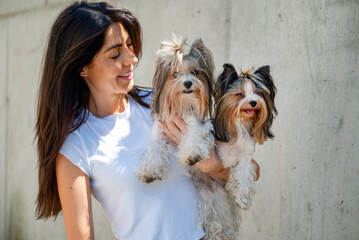Beautiful smiling woman hugging two yorkies dogs 