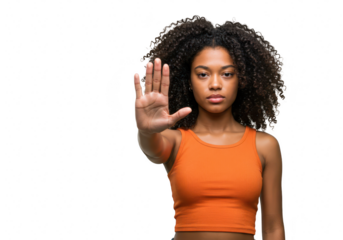 A young african american woman with curly hair holds up her hand in a stop gesture, isolated on a transparent background