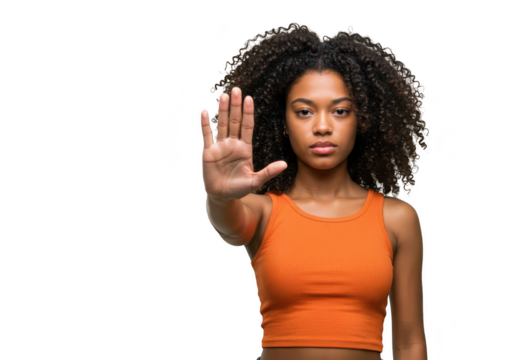 A young african american woman with curly hair holds up her hand in a stop gesture, isolated on a transparent background