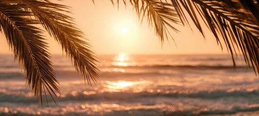 The serene sunset over the ocean with palm leaves in the foreground.