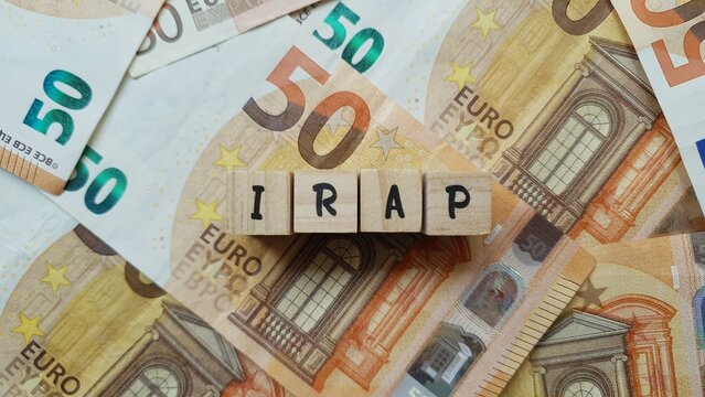 IRAP acronym made of wooden letter cubes on pile of Euro banknotes. Imposta Regionale sulle Attivit&agrave; Produttive (Regional Tax on Productive Activities)