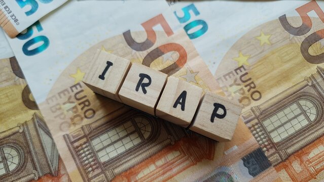 IRAP acronym made of wooden letter cubes on pile of Euro banknotes. Imposta Regionale sulle Attivit&agrave; Produttive (Regional Tax on Productive Activities)