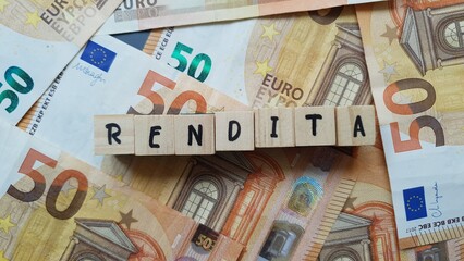 RENDITA (Annuity) word made of wooden letter cubes on pile of Euro banknotes