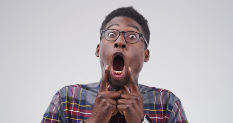Goofy, black man and portrait with funny face for joke or expression on a white studio background....