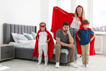 Portrait of parents and children in superhero costumes at home