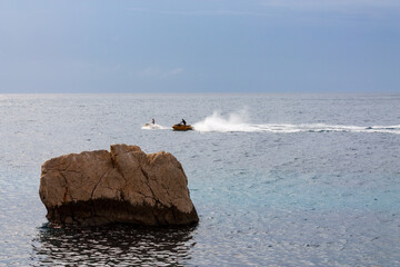 Motor Sport activities, JetSki cruising on calm sea water during the day.
