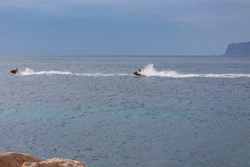 Personal Watercraft Motor Sport activities, JetSki cruising on calm sea water during the day.
