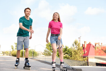 Fototapeta premium Happy couple roller skating together on street