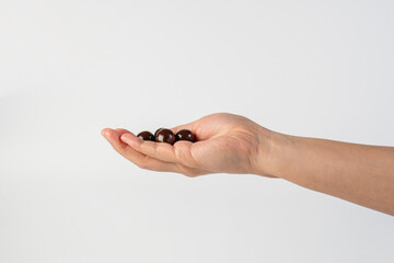 Chocolate ball in hand on white background