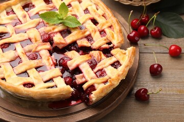 Tasty cut cherry pie and berries on wooden table, closeup