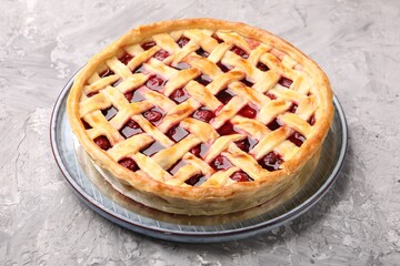 Tasty cherry pie on grey textured table, closeup