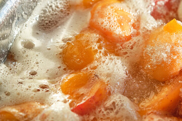 Cooking apricot confiture with foam. Shallow depth of field