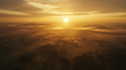 Obraz premium Golden sunrise over a misty landscape