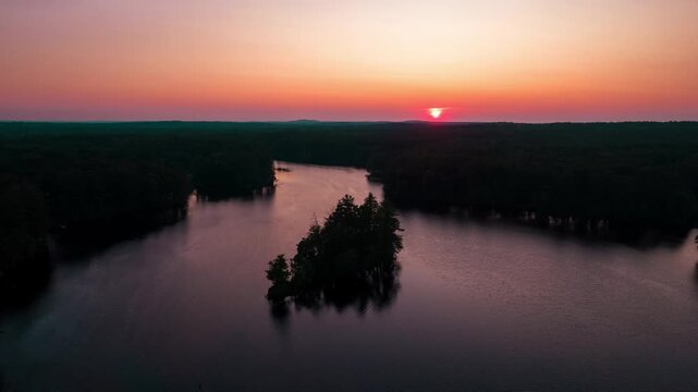 Hyperlapse drone flight over Harold Parker State Forest in Massachusetts, USA. Golden sunset with natural lake in nature of the USA.