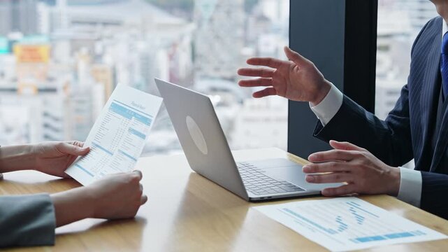 A group of business people having a meeting in an office while looking at a computer screen