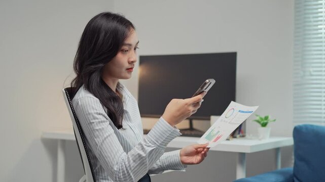 Businesswoman scanning documents with smartphone in modern office