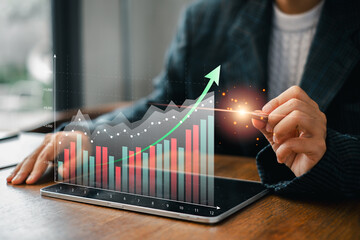 A business professional examines financial data on a tablet, highlighting growth trends with...