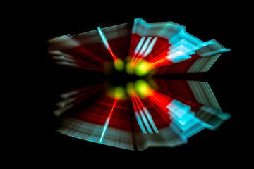 a dynamic, blurred motion of a light pattern reflecting on a glossy black surface, creating a...