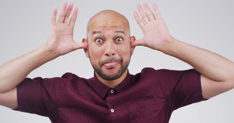 Goofy, funny face and portrait of man in studio with crazy, silly and comic facial expression....