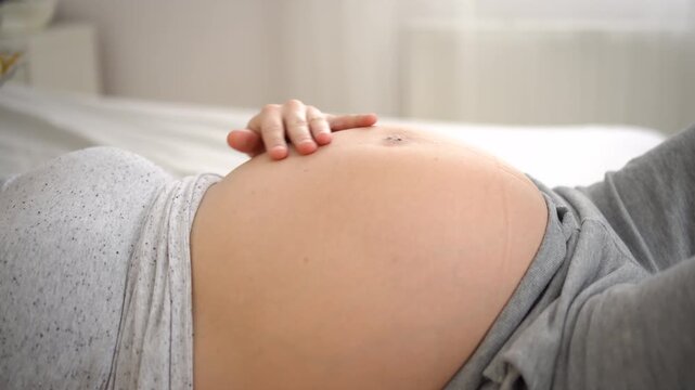 Close-up of a pregnant woman belly with visible baby movements. Intimate and emotional moment of pregnancy, showing connection between mother and unborn child.