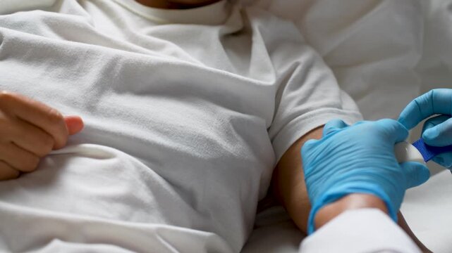 Nurse setting IV drip for patient lying in hospital bed