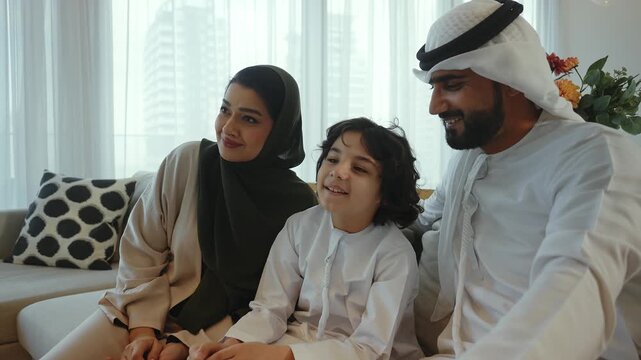 Arab family, father, mother, and son, pose together on a sofa in their modern living room, creating a heartwarming portrait of family unity