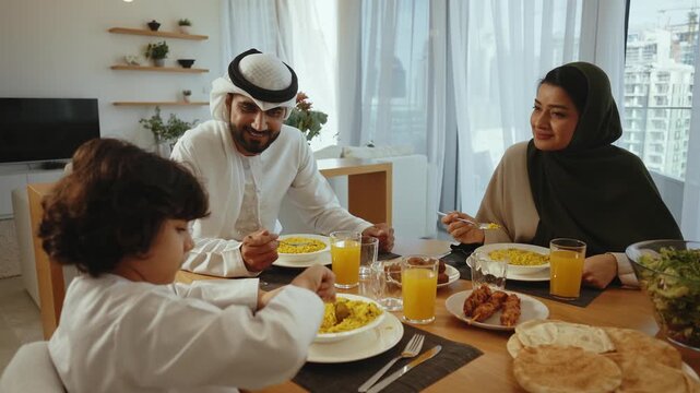 Multigenerational muslim family sharing warm meal together, sitting around dining table, enjoying traditional arabic cuisine with smiling interaction and familial connection