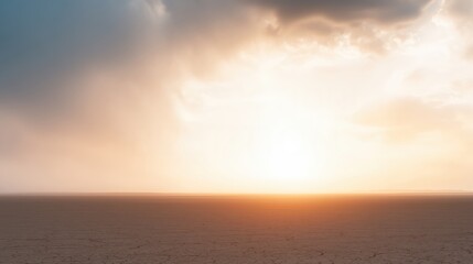 Obraz premium Expansive desert landscape at sunset, showcasing vast dry terrain with cracked earth, illuminated by warm golden light and dramatic clouds, creating a serene and tranquil atmosphere