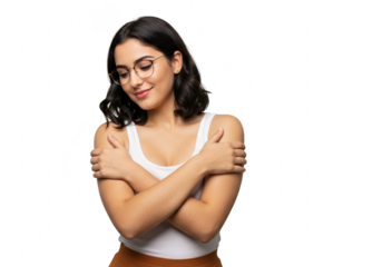 A young woman with short dark wavy hair and glasses hugs herself with a content smile, looking down, isolated on a transparent background