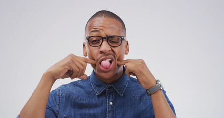 Portrait, funny face and black man in studio with silly facial expression on white background....