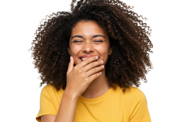 A joyful young woman with curly black hair laughs heartily, covering her mouth with her hand, isolated on a transparent background