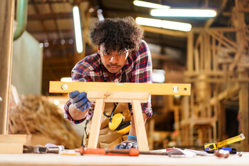 Professional African male carpenter is working professionally in sawmill - workshop.